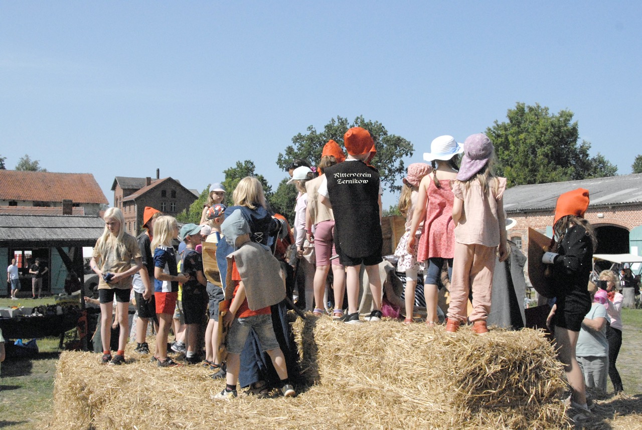 Kinder spielen auf Heuballen